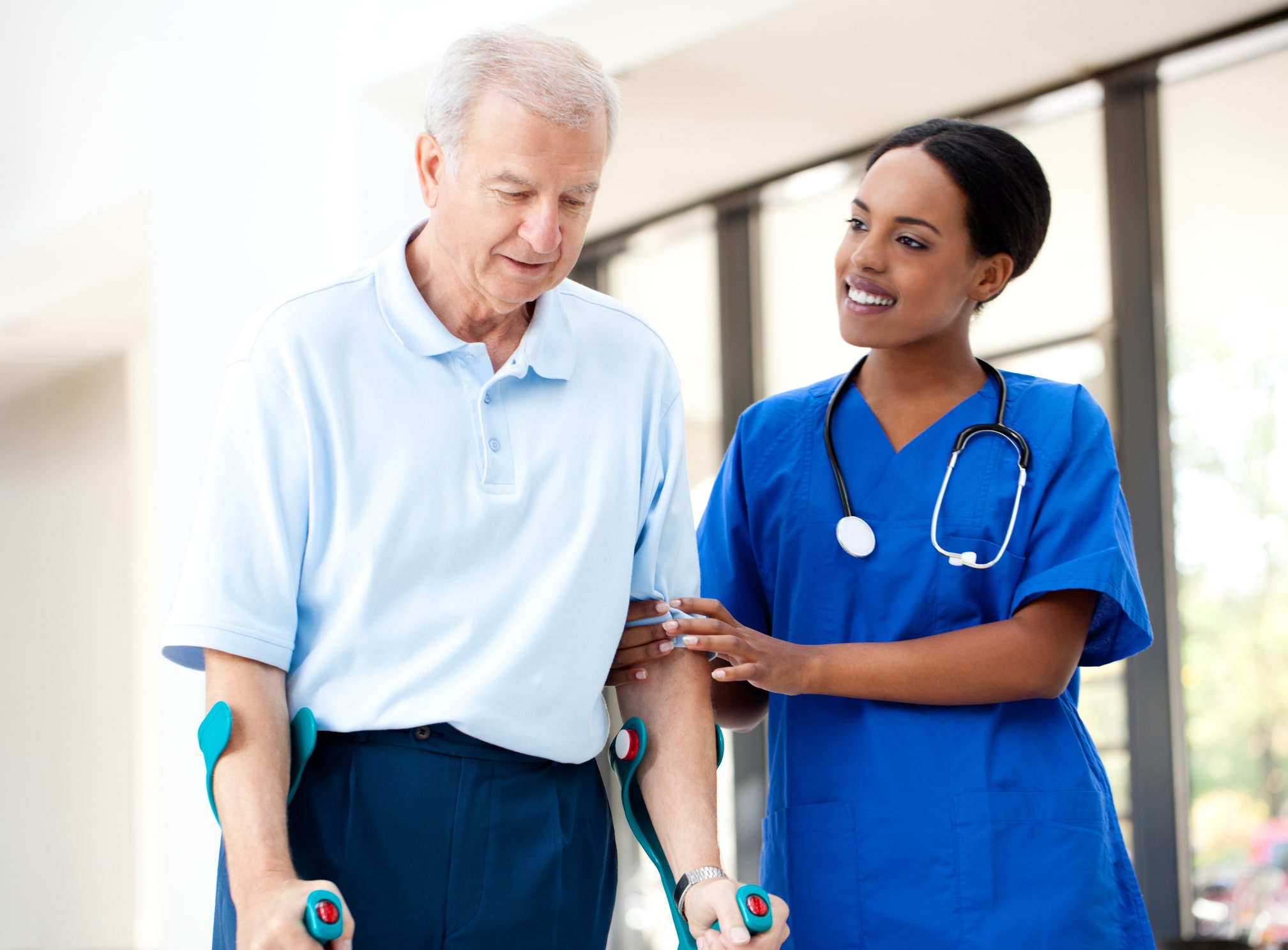 Nurse holding the left arm of a patient to help him walk